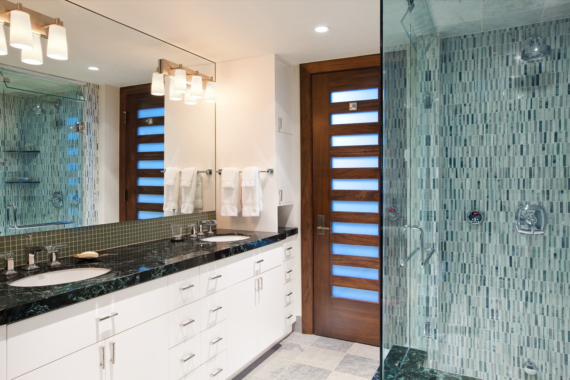 a view of a bathroom with white cabinets and blue tile in the Bell Tower project in Vail, CO