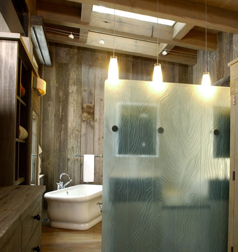 a frosted glass door in front of a rustic wooden bathroom at watersong