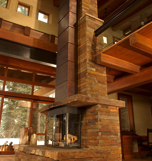 a two story contemporary fireplace in the living room at watersong